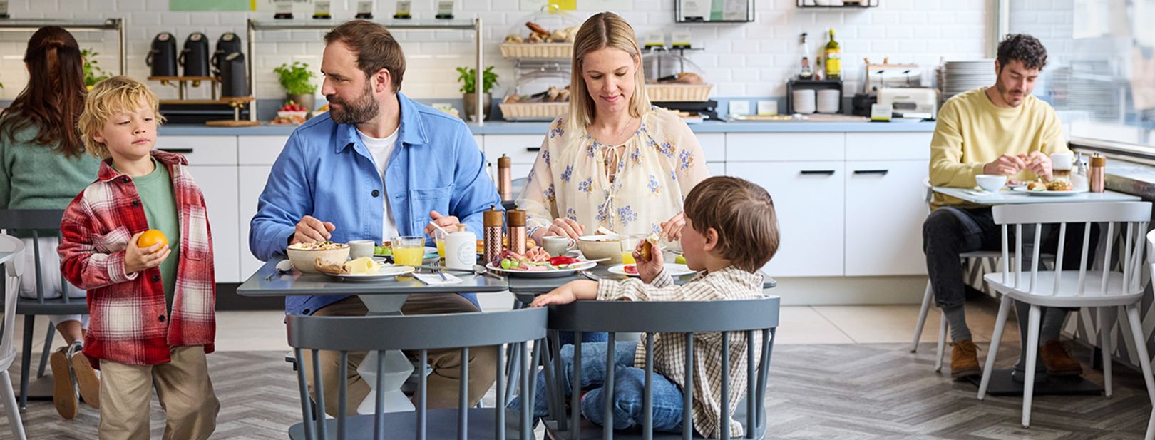 A family of four sitting at a table for breakfast